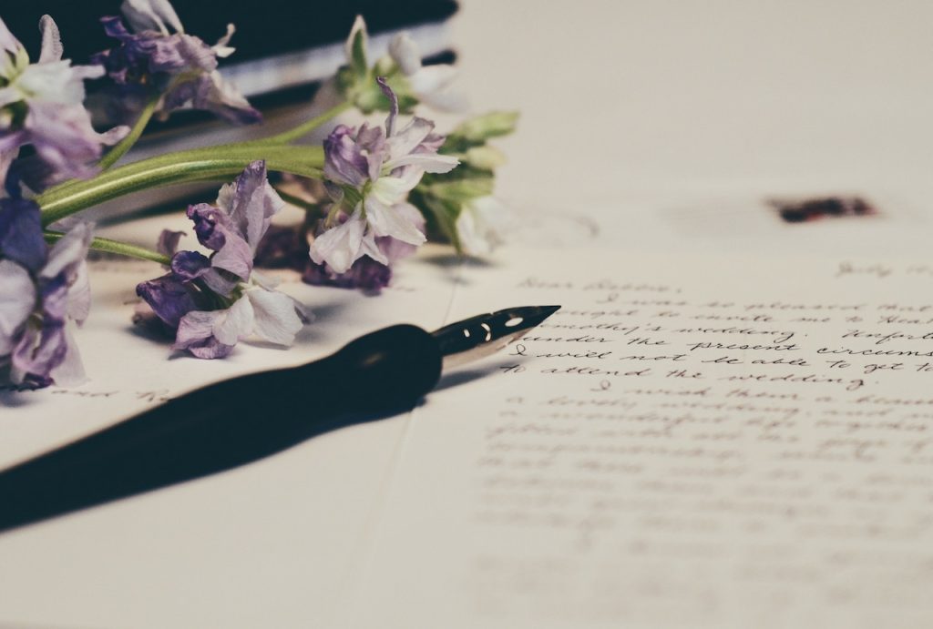 a pen and flower cuttings on a piece of paper